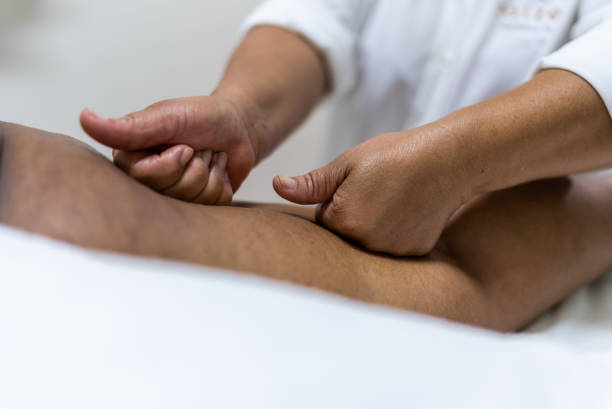 esthéticienne massant un client dans un spa de beauté - drainage lymphatique corps photos et images de collection