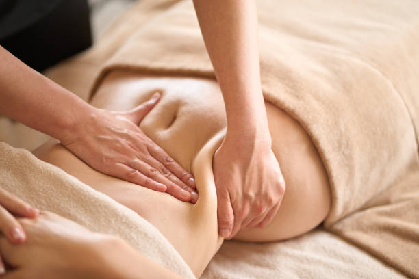 une femme recevant un massage du ventre dans un salon de beauté - massage photos et images de collection